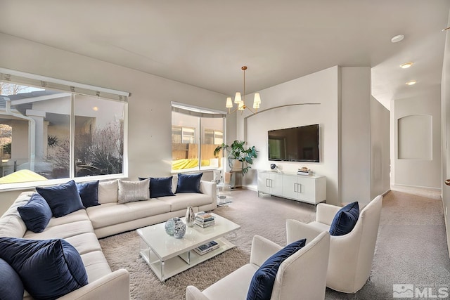 carpeted living room featuring an inviting chandelier and a healthy amount of sunlight