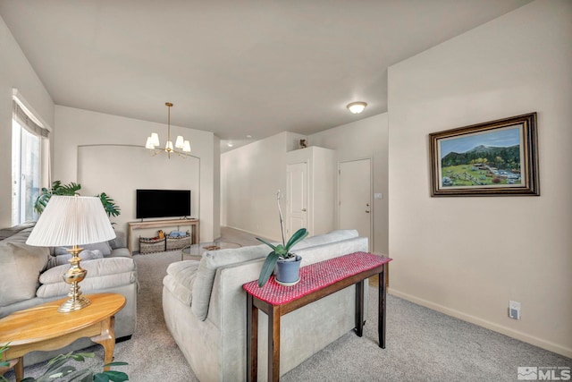 carpeted living room with an inviting chandelier