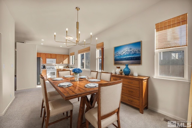 dining space with an inviting chandelier, plenty of natural light, and light colored carpet