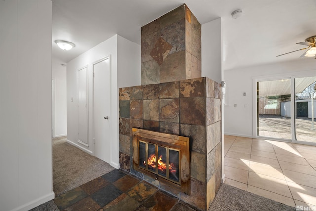 room details with a tile fireplace, ceiling fan, and carpet