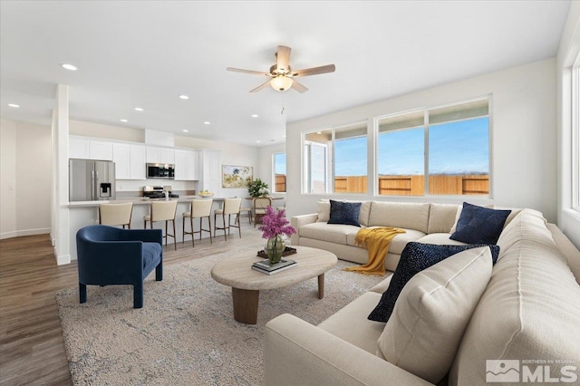 living room featuring ceiling fan and hardwood / wood-style floors