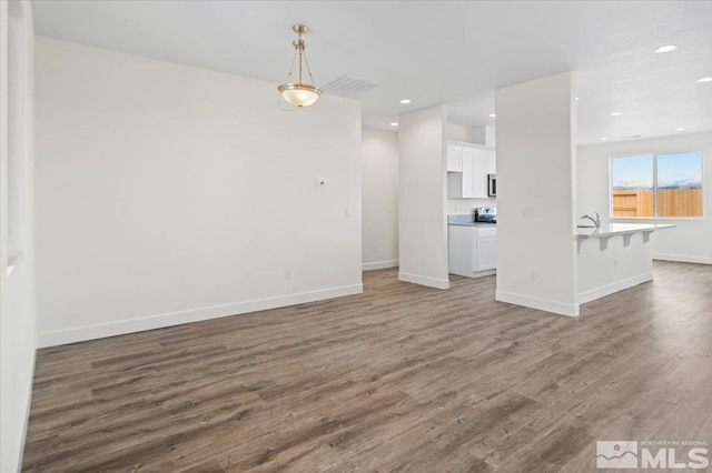 unfurnished living room featuring dark hardwood / wood-style flooring and sink