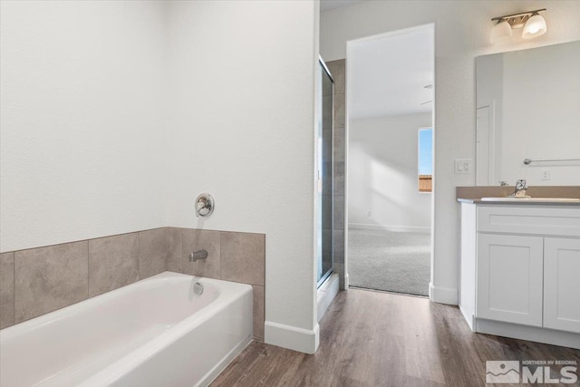 bathroom featuring vanity, hardwood / wood-style floors, and plus walk in shower