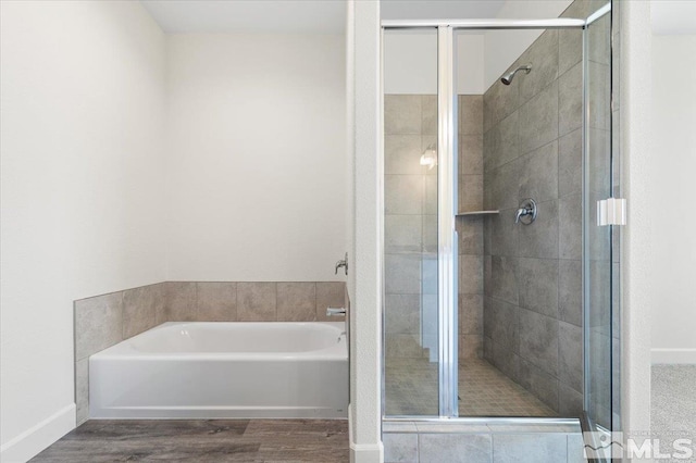 bathroom featuring wood-type flooring and plus walk in shower