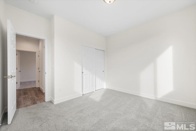 unfurnished bedroom with a closet and carpet flooring