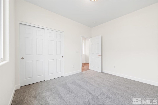 unfurnished bedroom featuring carpet flooring and a closet