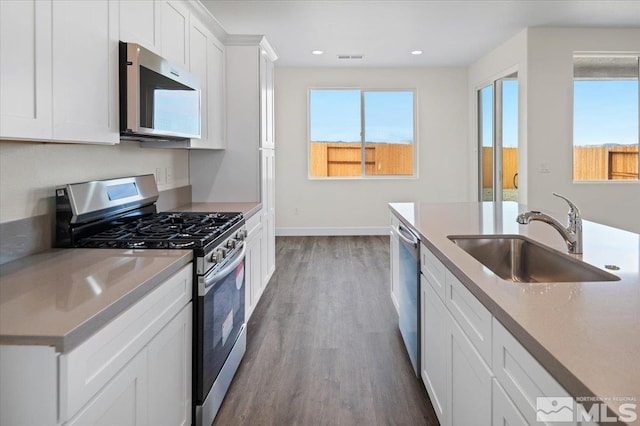 kitchen with sink, white cabinetry, hardwood / wood-style floors, and appliances with stainless steel finishes