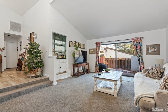 carpeted living room featuring high vaulted ceiling