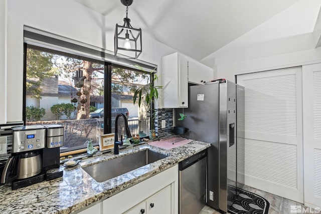 kitchen featuring sink, decorative light fixtures, white cabinets, light stone countertops, and appliances with stainless steel finishes