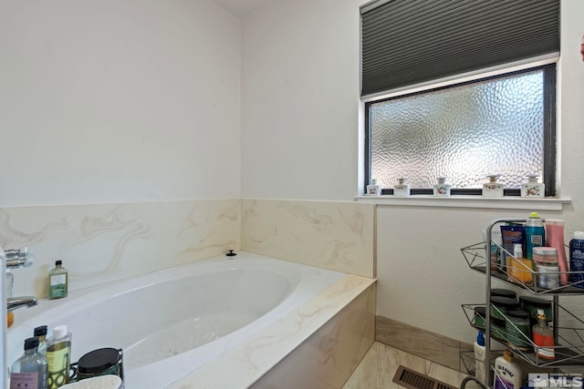 bathroom with a relaxing tiled tub, tile patterned flooring, and plenty of natural light