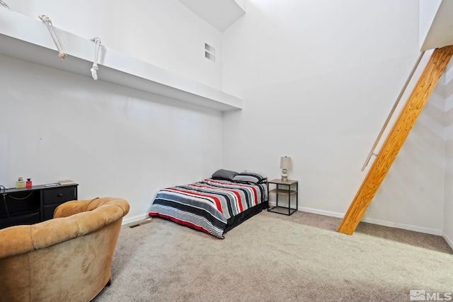 bedroom featuring a high ceiling and light carpet