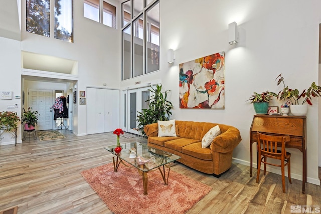 living room with a high ceiling and light wood-type flooring