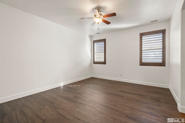 spare room featuring ceiling fan and dark wood-type flooring