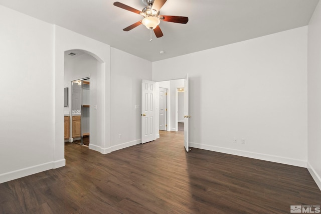 empty room featuring dark wood-type flooring and ceiling fan