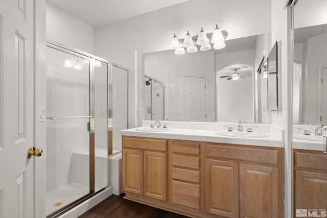 bathroom with hardwood / wood-style flooring, an enclosed shower, ceiling fan, and vanity