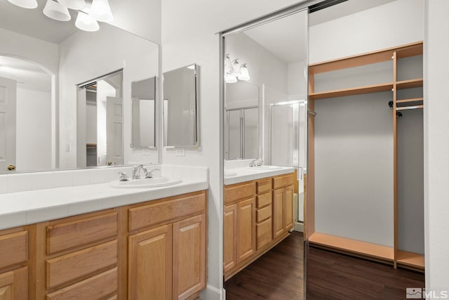 bathroom featuring walk in shower, hardwood / wood-style floors, and vanity