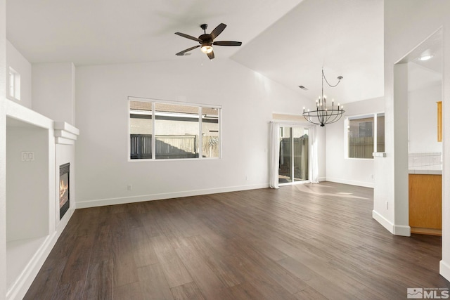 unfurnished living room featuring dark hardwood / wood-style flooring, lofted ceiling, and ceiling fan with notable chandelier