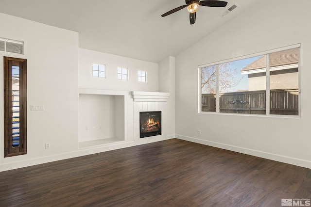 unfurnished living room featuring dark hardwood / wood-style flooring, a tiled fireplace, ceiling fan, and vaulted ceiling