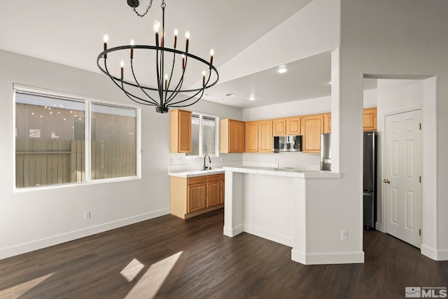 kitchen with vaulted ceiling, a notable chandelier, dark wood-type flooring, refrigerator, and sink