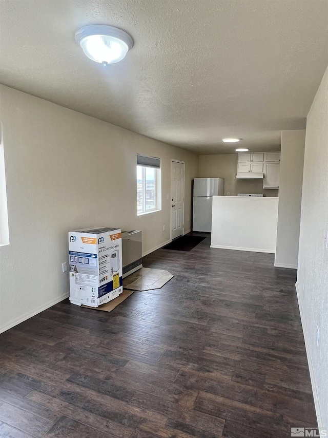 interior space featuring a textured ceiling and dark hardwood / wood-style flooring