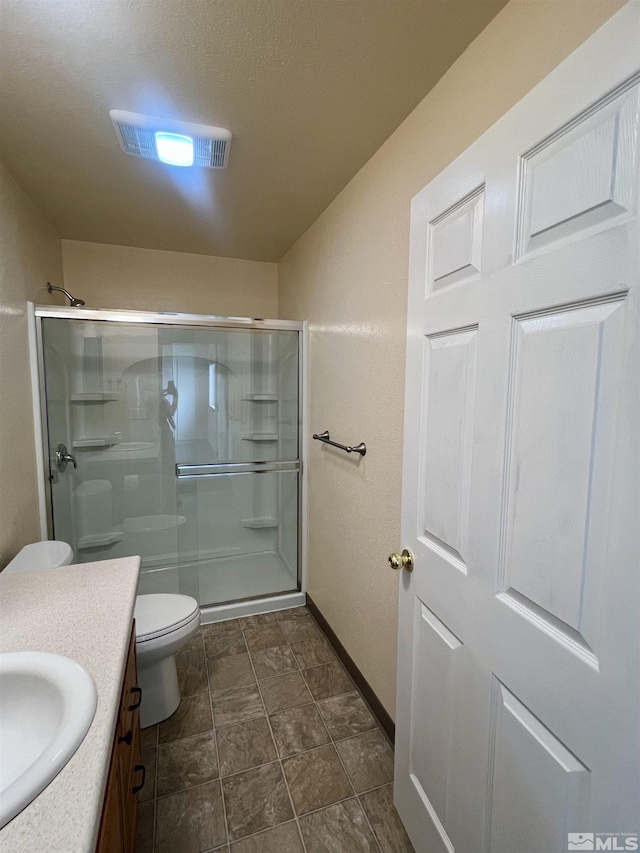 bathroom with an enclosed shower, vanity, and toilet