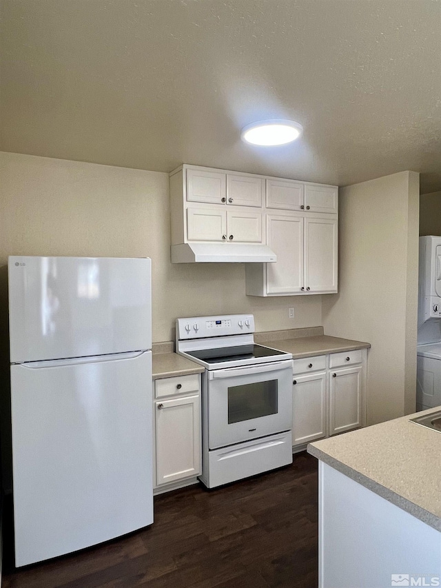 kitchen featuring white appliances, dark wood-type flooring, white cabinets, and stacked washer / dryer