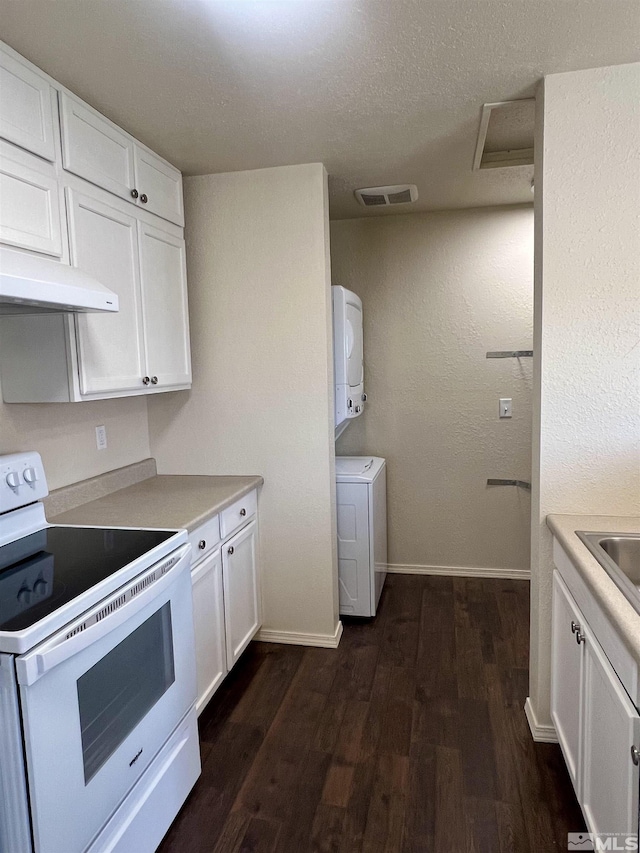 kitchen featuring dark hardwood / wood-style flooring, white electric stove, stacked washer / dryer, and white cabinetry