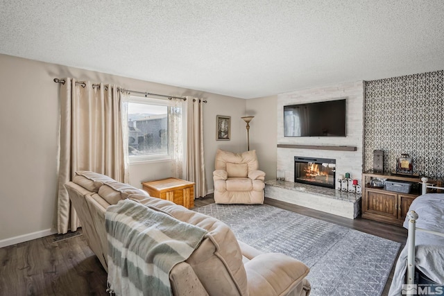 living room with a fireplace, a textured ceiling, and dark hardwood / wood-style flooring