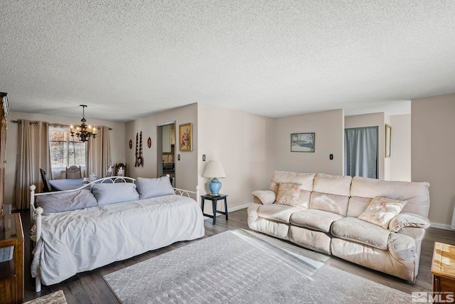 bedroom featuring a textured ceiling, a chandelier, and dark wood-type flooring