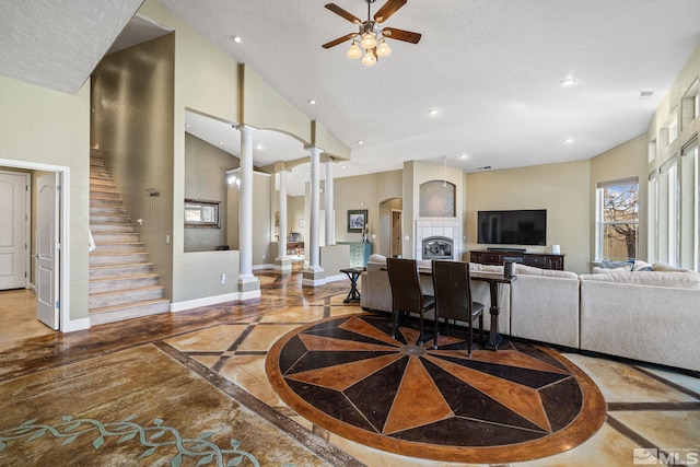 living room featuring a high ceiling, decorative columns, and ceiling fan