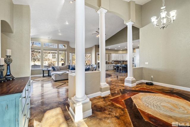 entryway featuring ceiling fan with notable chandelier and a high ceiling