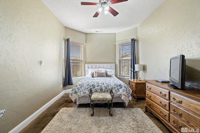 carpeted bedroom featuring ceiling fan and a textured ceiling