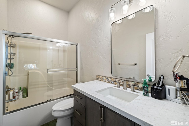 full bathroom featuring toilet, vanity, and combined bath / shower with glass door