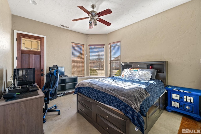 carpeted bedroom with a textured ceiling and ceiling fan