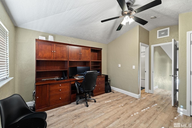 home office featuring lofted ceiling, a textured ceiling, ceiling fan, and light hardwood / wood-style flooring