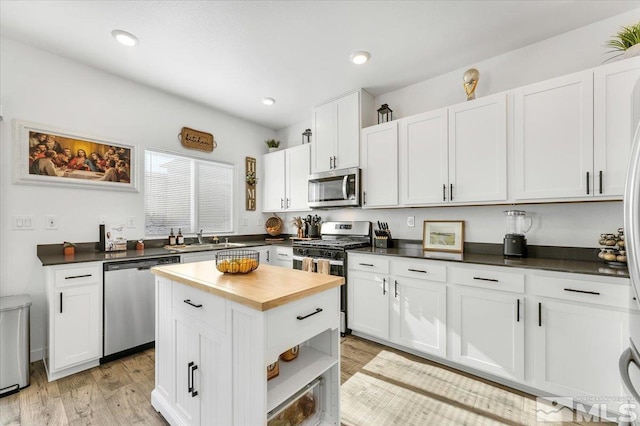 kitchen featuring white cabinets, light wood-type flooring, appliances with stainless steel finishes, and sink