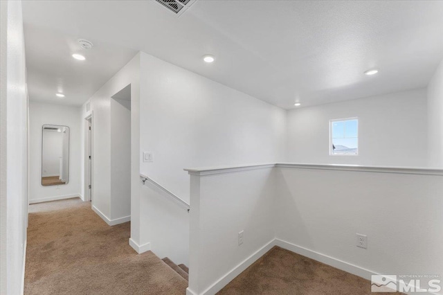 corridor featuring light colored carpet