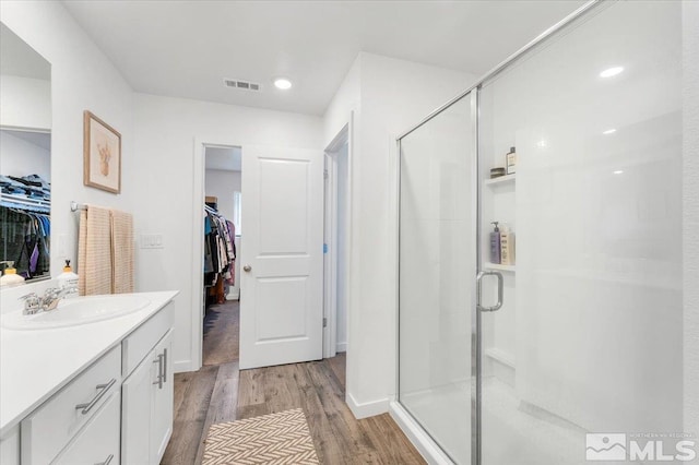 bathroom with a shower with door, vanity, and hardwood / wood-style floors