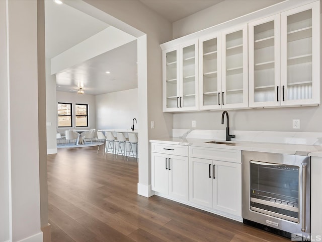 bar featuring light stone counters, ceiling fan, wine cooler, and white cabinetry