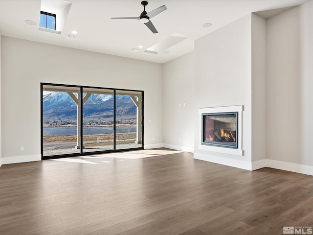 unfurnished living room with ceiling fan and hardwood / wood-style floors