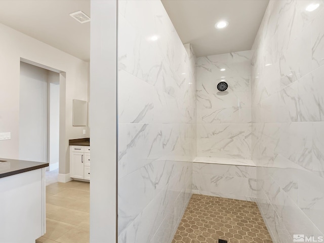 bathroom featuring tiled shower and vanity