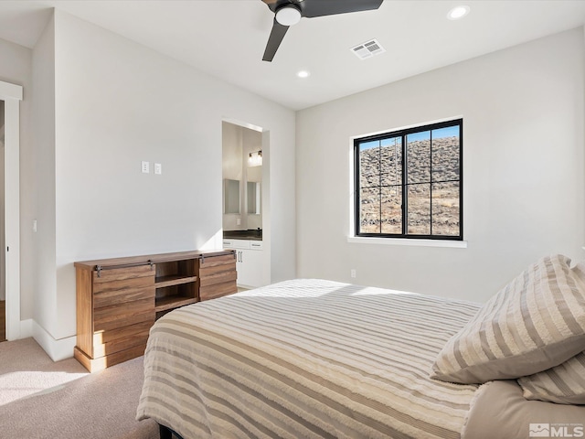 carpeted bedroom featuring ensuite bath and ceiling fan