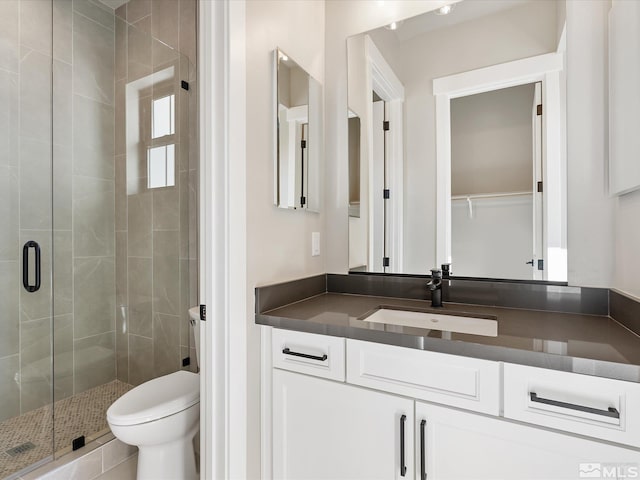 bathroom with toilet, walk in shower, and vanity