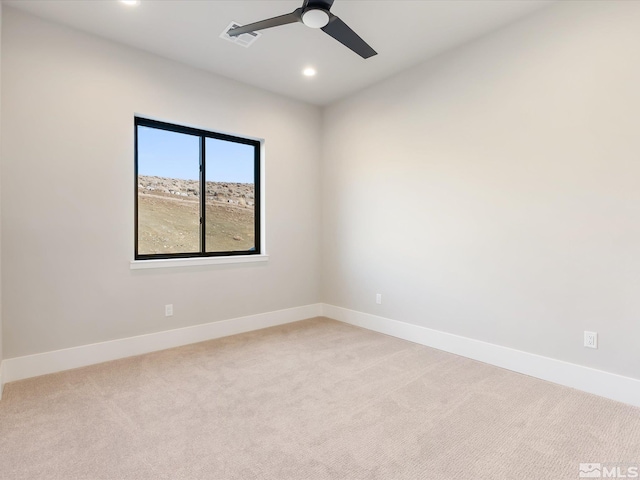 empty room with ceiling fan and light carpet