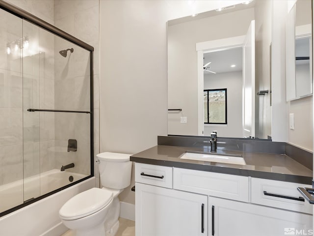 full bathroom featuring toilet, bath / shower combo with glass door, ceiling fan, and vanity