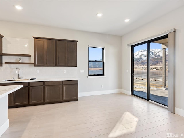 kitchen featuring sink, tasteful backsplash, dark brown cabinets, and a mountain view