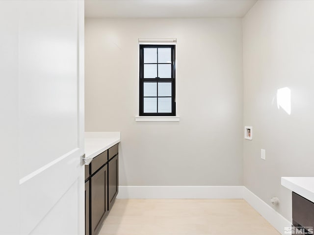 washroom featuring washer hookup and light hardwood / wood-style flooring