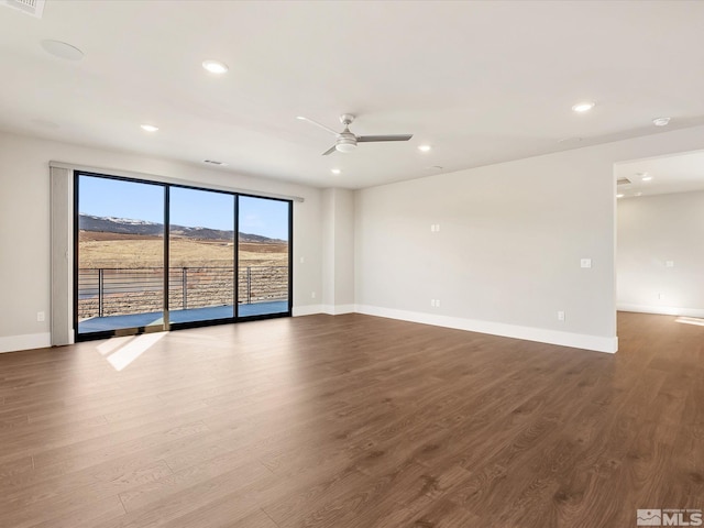 spare room featuring ceiling fan, hardwood / wood-style flooring, and a mountain view