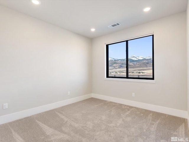 spare room featuring carpet floors and a mountain view