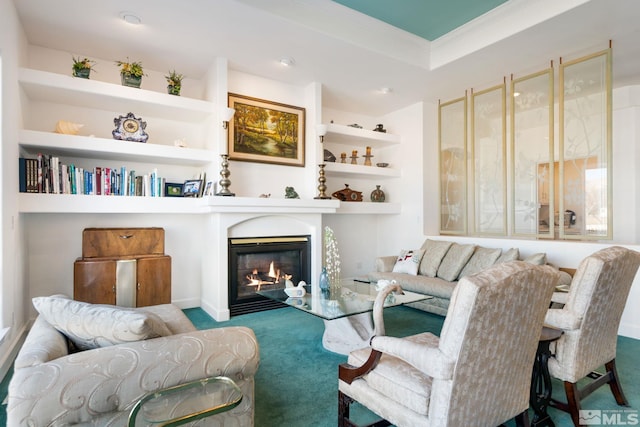 sitting room with ornamental molding, built in features, and carpet flooring